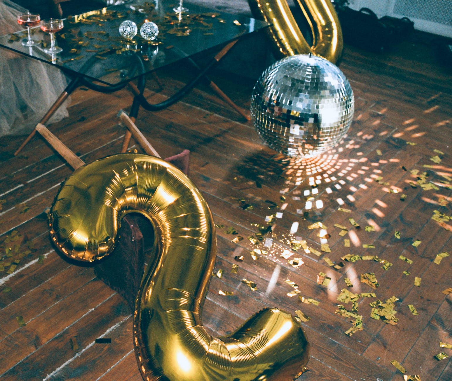 gold number two balloon and disco ball on the floor
